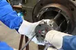 Techniker mit Schutzhandschuhen montieren oder demontieren eine industrielle mechanische Dichtung an einer großen Maschine.